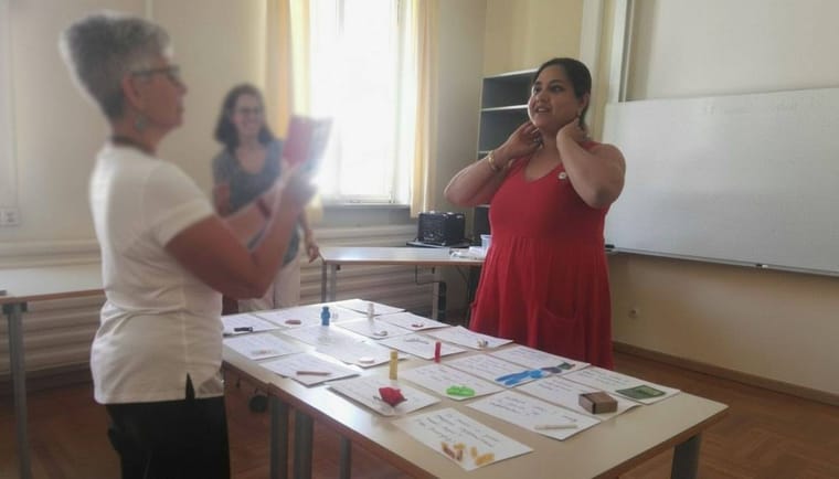 Lali Banerji leading a hands-on language workshop around a table of handwritten cards
